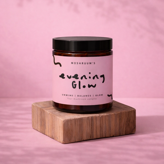 Jar of 'Evening Glow' on a wooden block with a pink background