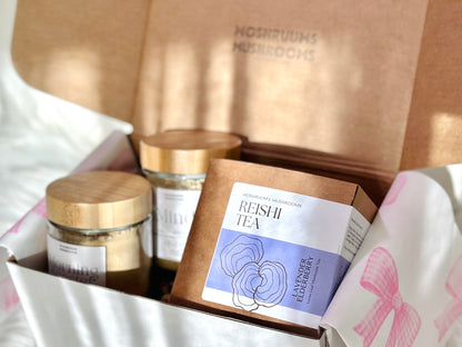 Tea packaging with jars and a box labeled 'Reishi Tea' on a white surface.