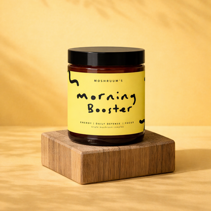 Jar labeled 'Morning Booster' triple mushroom complex powder on a wooden block with a yellow background
